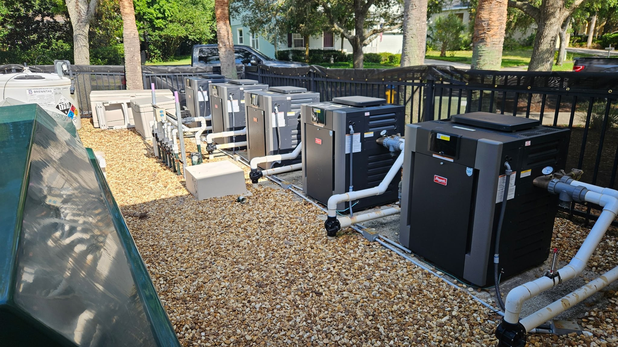 Large-scale commercial pool equipment room with filtration tanks and piping