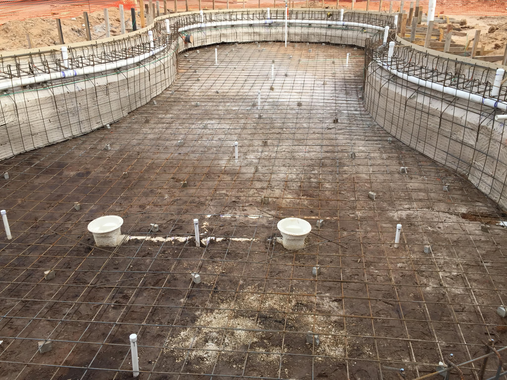 Rebar steel cage forming the structural shell of a commercial freeform pool before shotcrete