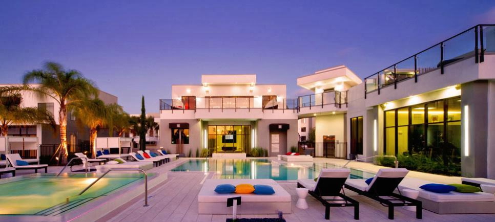 Resort-style commercial pool at dusk with lounge chairs and modern architecture, built by Arinton