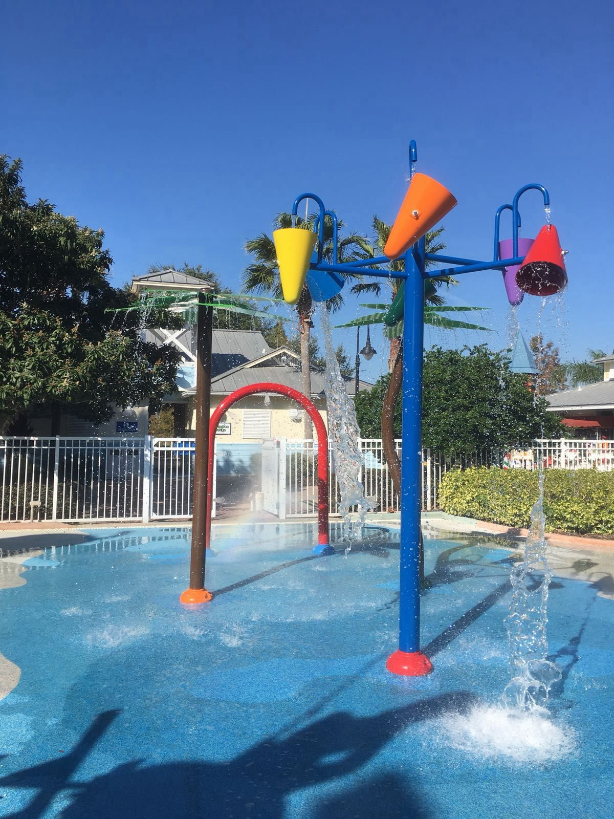 Colorful interactive splash pad with cone fountains and dump buckets at an Arinton-built community waterpark
